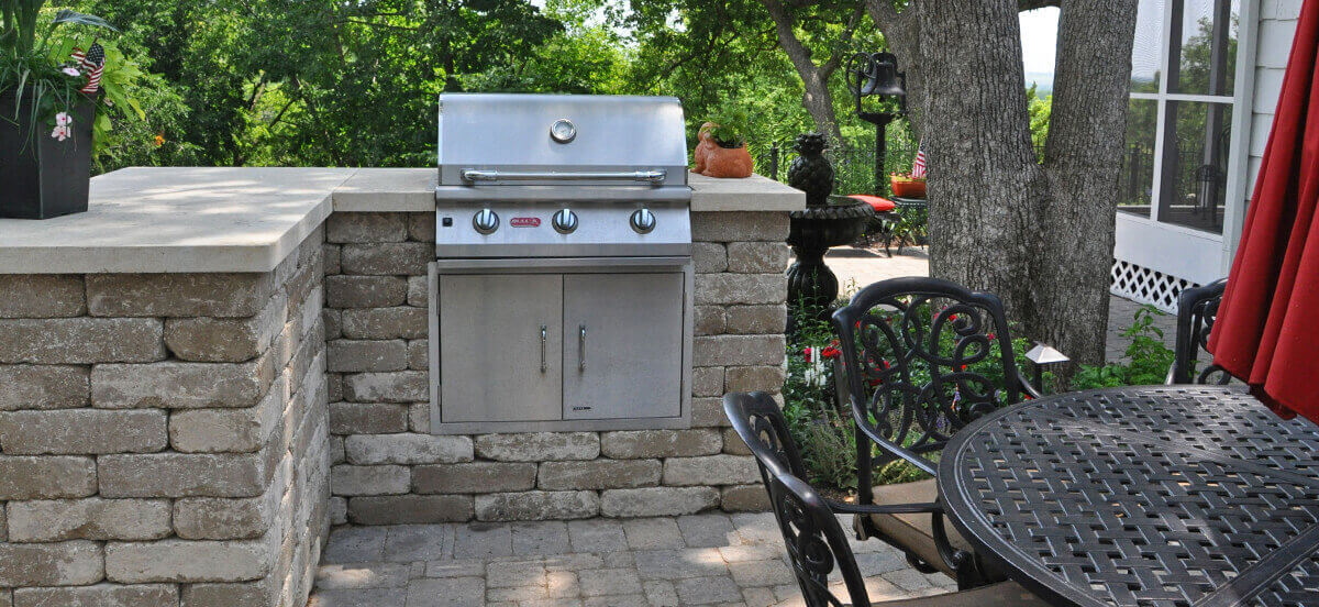 Outdoor living area with built-in grill, completed by Embassy Landscape Group.