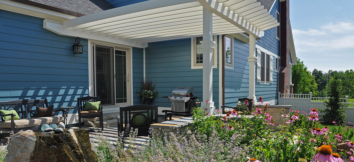 Outdoor living area with pergola and grill, completed by Embassy Landscape Group.