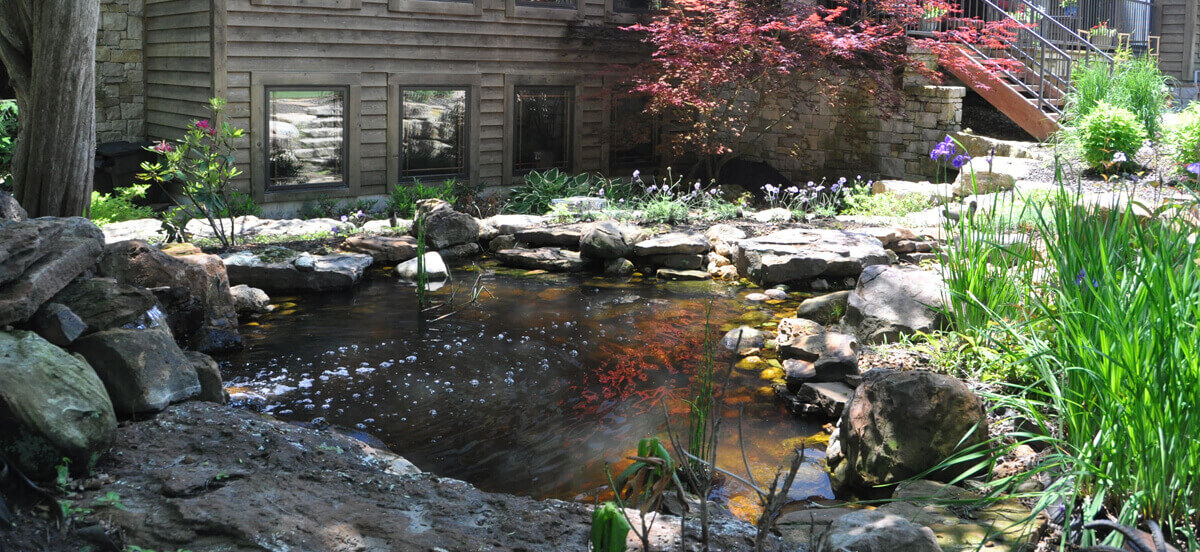 Outdoor living area with pond, completed by Embassy Landscape Group.