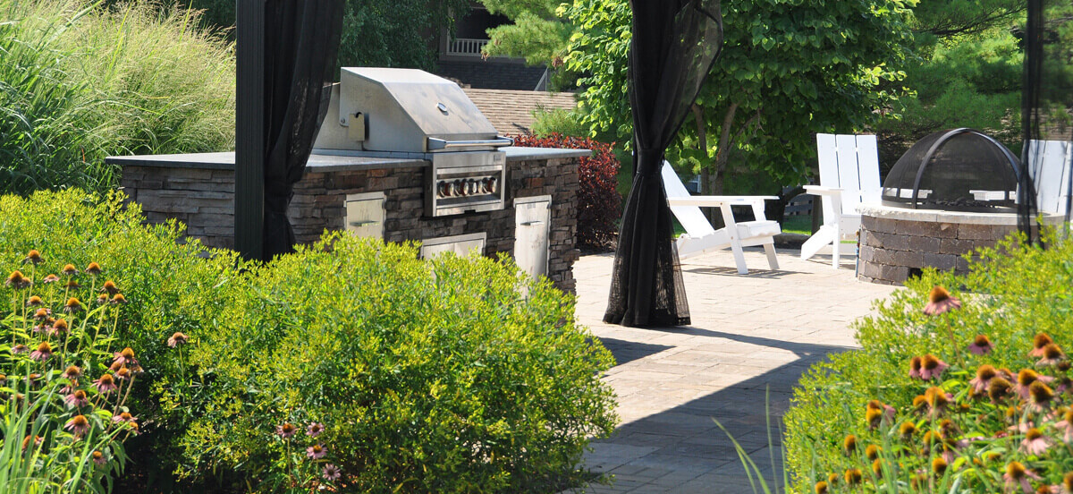 Landscape design with grill and firepit, completed by Embassy Landscape Group.